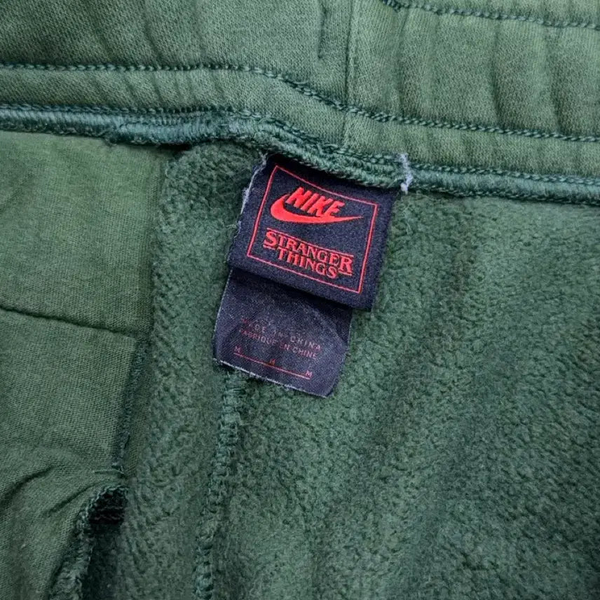 [BUNJANG] Nike x Stranger Things Hawkins High Green Sweatpants M / 나이키 x 기묘한 이야기 호킨스고 그린 스웻팬츠 M
