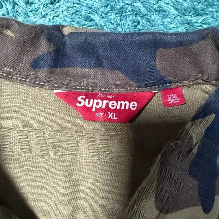 [BUNJANG] Supreme Jacquard Logo Denim Trucker Jacket Woodland Camo FW25 / 슈프림 자카드 로고 데님 트러커 자켓 우드랜드 카모 - 25FW